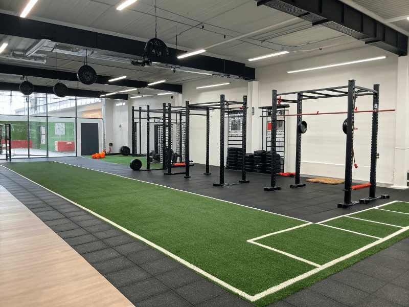 A modern functional fitness area with gym turf and rubber flooring.