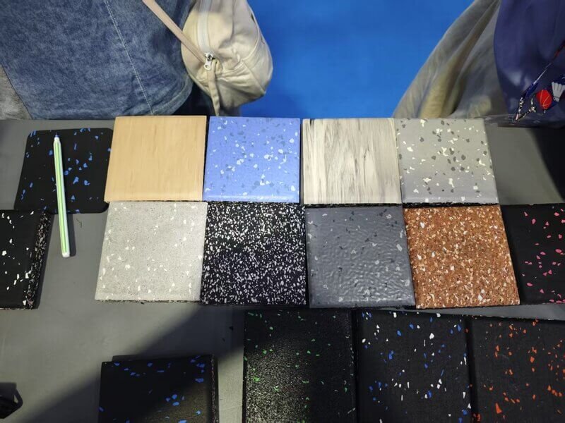 A gym owner looking at flooring samples while standing near a squat rack.