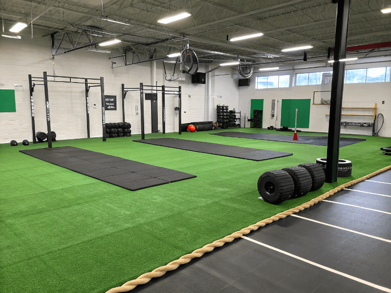 Functional training area with green gym turf and black rubber flooring