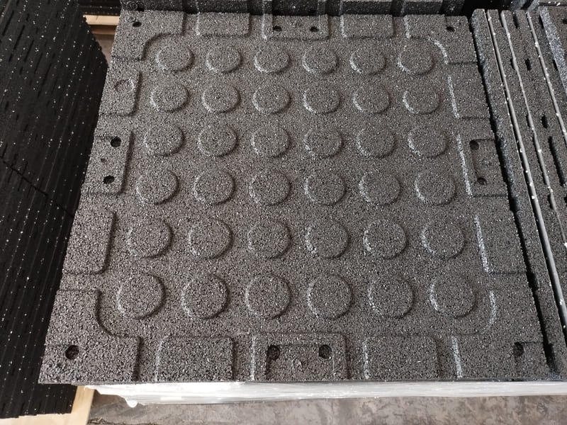 Side view diagram comparing flat bottom rubber tile vs waffle bottom grid design for shock absorption